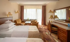 Pokój hotelowy z dwoma łóżkami, kanapą i biurkiem. Dowiedz się, ile kosztuje nocleg w hotelu Gołębiewski.