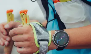 Zegarek z mapą szlaku na nadgarstku, idealny jako jaki zegarek w góry. Dłonie trzymają kijki trekkingowe Leki.