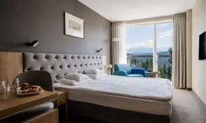Pokój w hotelu Harnaś Wierch, Bukowina Tatrzańska. Wygodne łóżko, fotel i widok na góry.