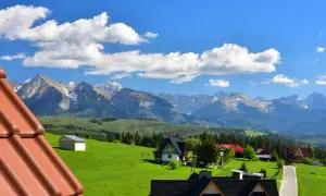 Widok na góry Tatry z zielonymi łąkami i domami w Rzepiskach.
