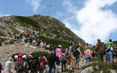 Tłum turystów wspina się na Giewont. Ile czasu zajmuje wejście na Giewont? Zależy od kondycji i pogody, ale widok jest wart wysiłku!