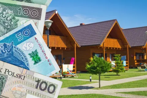 Polskie banknoty i drewniane domki letniskowe. Zastanawiasz się, gdzie szukać noclegu?