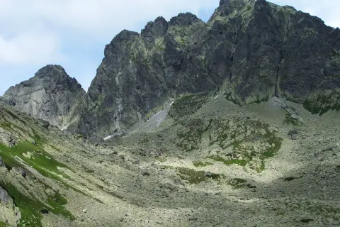 Kamieniste zbocza i skaliste szczyty górskie, gdzie widać ślady szlaków. Kozi Wierch w oddali.