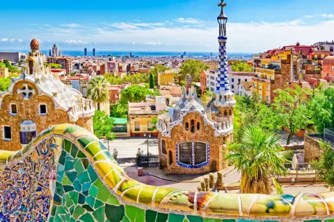 Kolorowe mozaiki Parku Güell w Barcelonie, idealne miejsce na noclegi. Widok na miasto i morze.