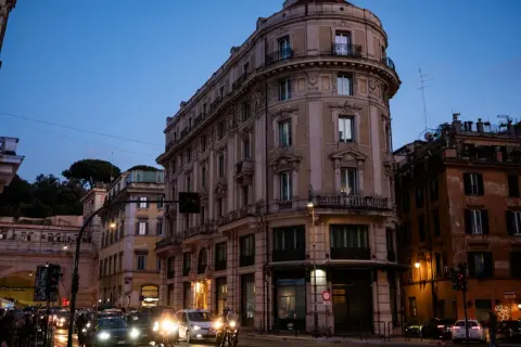 Wieczorny Rzym, ruchliwe skrzyżowanie. Zastanawiasz się, gdzie najlepiej nocleg w Rzymie? To miasto oferuje wiele opcji.