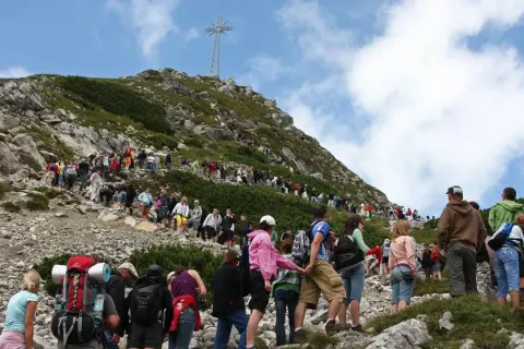 Tłum turystów wspina się na Giewont. Ile czasu zajmuje wejście na Giewont? Zależy od kondycji i pogody, ale widok jest wart wysiłku!