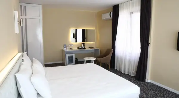 Przytulny pokój hotelowy z dużym łóżkiem, biurkiem, minibarem i klimatyzacją. Sprawdź, ile kosztuje nocleg w tym miejscu.