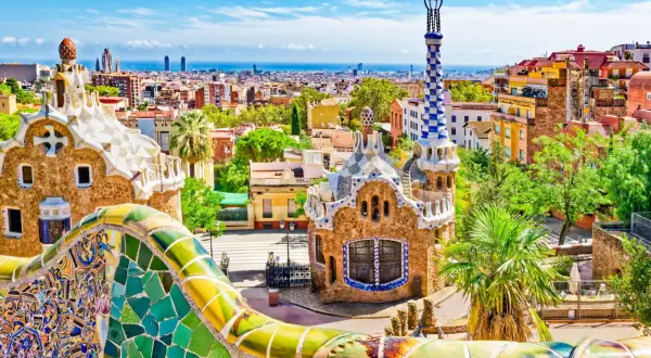 Kolorowe mozaiki Parku Güell w Barcelonie, idealne miejsce na noclegi. Widok na miasto i morze.