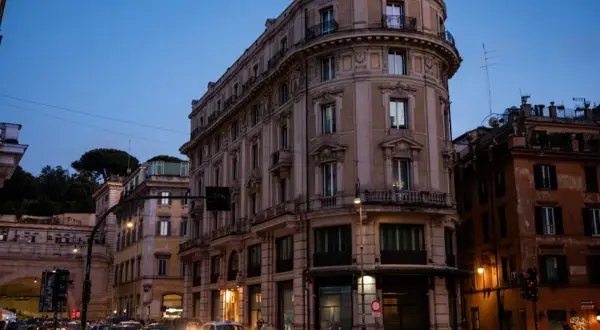 Wieczorny Rzym, ruchliwe skrzyżowanie. Zastanawiasz się, gdzie najlepiej nocleg w Rzymie? To miasto oferuje wiele opcji.