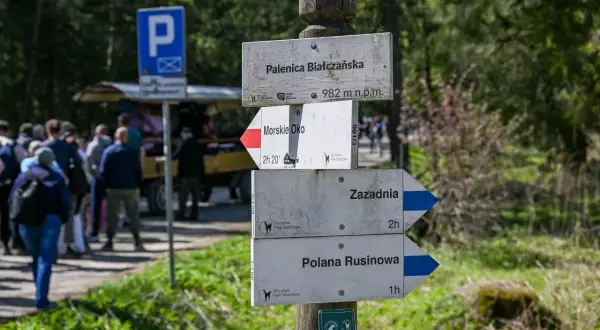 Drewniany słup z drogowskazami szlaków turystycznych w Tatrach: Palenica Białczańska, Morskie Oko, Zazadnia, Polana Rusinowa.