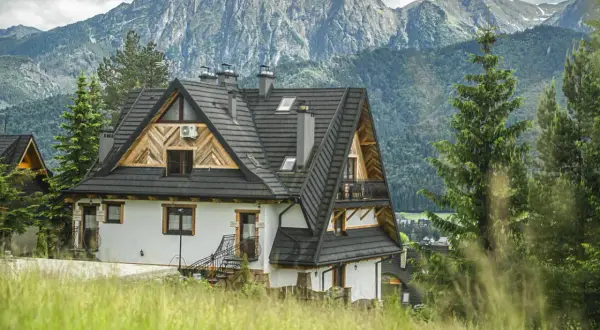 Apartamenty Butorowy Wierch w otoczeniu gór i zieleni. Dom w stylu góralskim z drewnianymi elementami.
