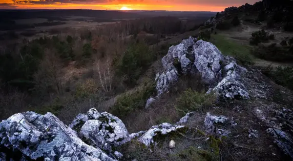 Zachód słońca nad Górami Świętokrzyskimi. Skaliste szczyty i lasy tworzą malowniczy krajobraz. Idealne miejsce, by zobaczyć piękno polskiej przyrody.