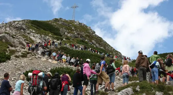 Tłum turystów wspina się na Giewont. Ile czasu zajmuje wejście na Giewont? Zależy od kondycji i pogody, ale widok jest wart wysiłku!