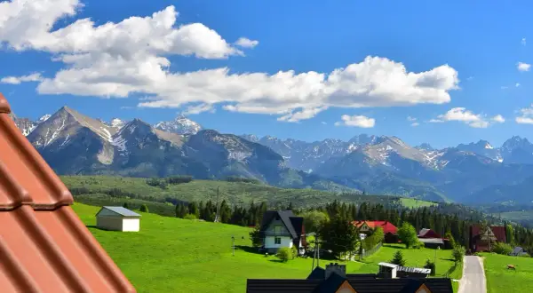 Widok na góry Tatry z zielonymi łąkami i domami w Rzepiskach.