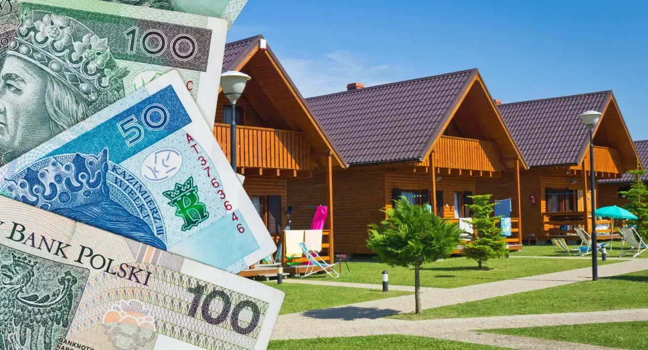 Polskie banknoty i drewniane domki letniskowe. Zastanawiasz się, gdzie szukać noclegu?