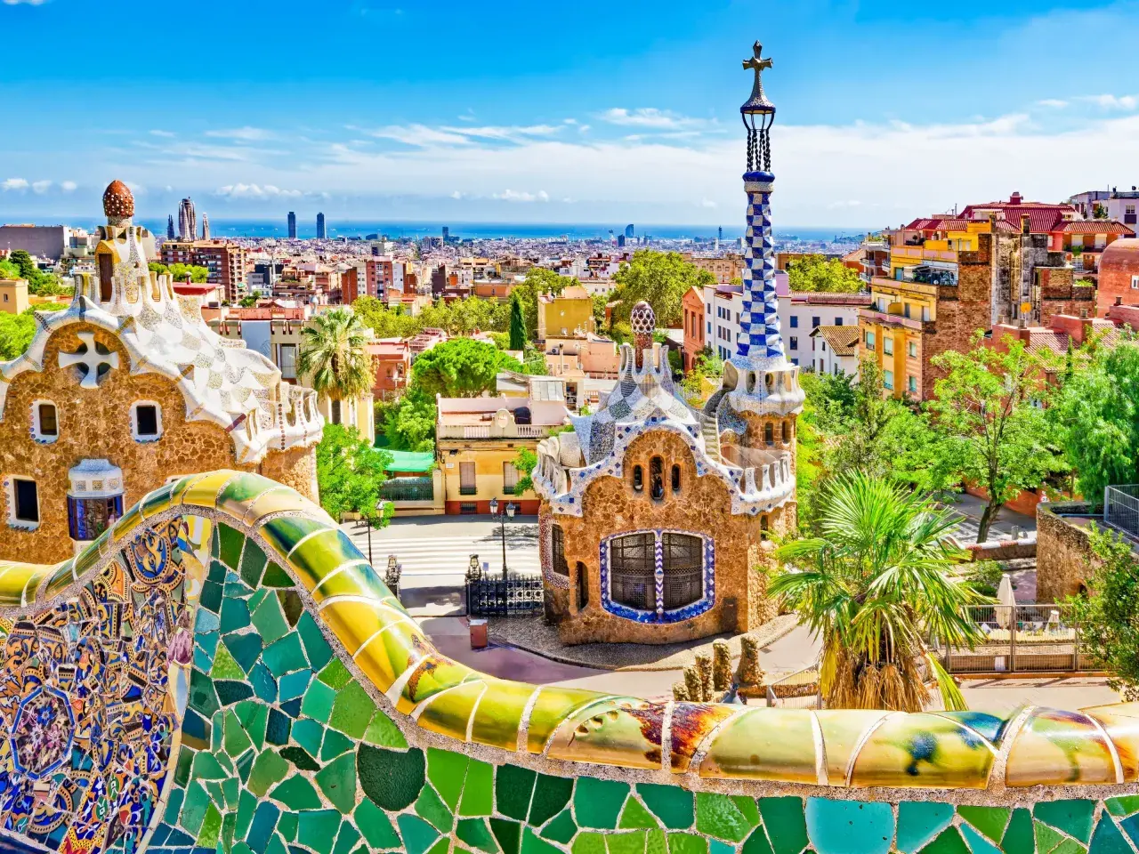 Kolorowe mozaiki Parku Güell w Barcelonie, idealne miejsce na noclegi. Widok na miasto i morze.