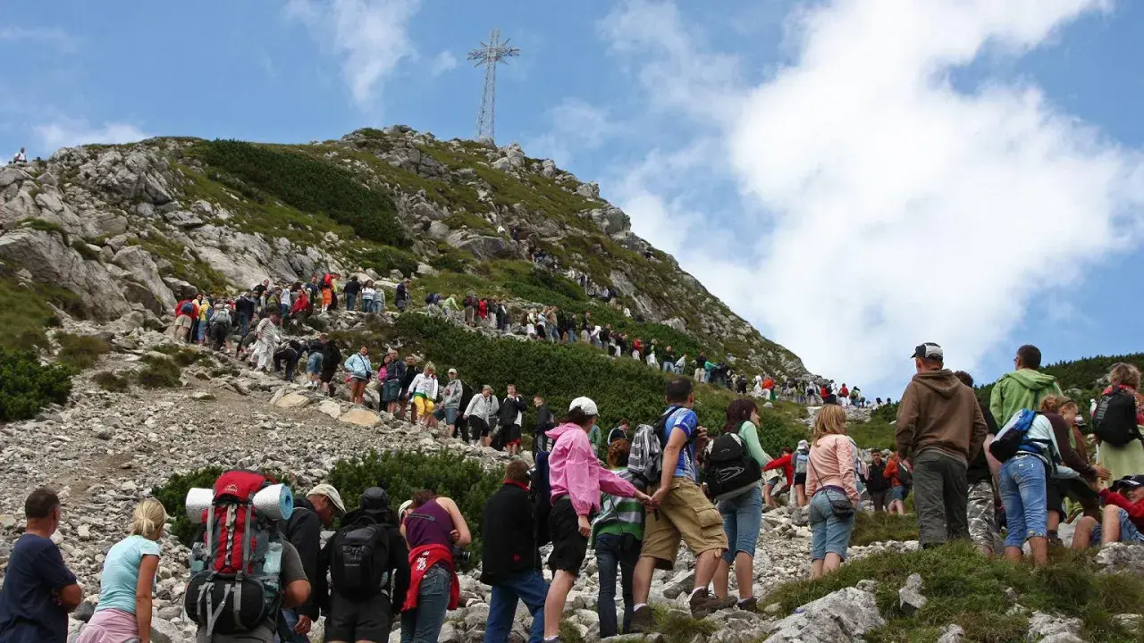 Tłum turystów wspina się na Giewont. Ile czasu zajmuje wejście na Giewont? Zależy od kondycji i pogody, ale widok jest wart wysiłku!