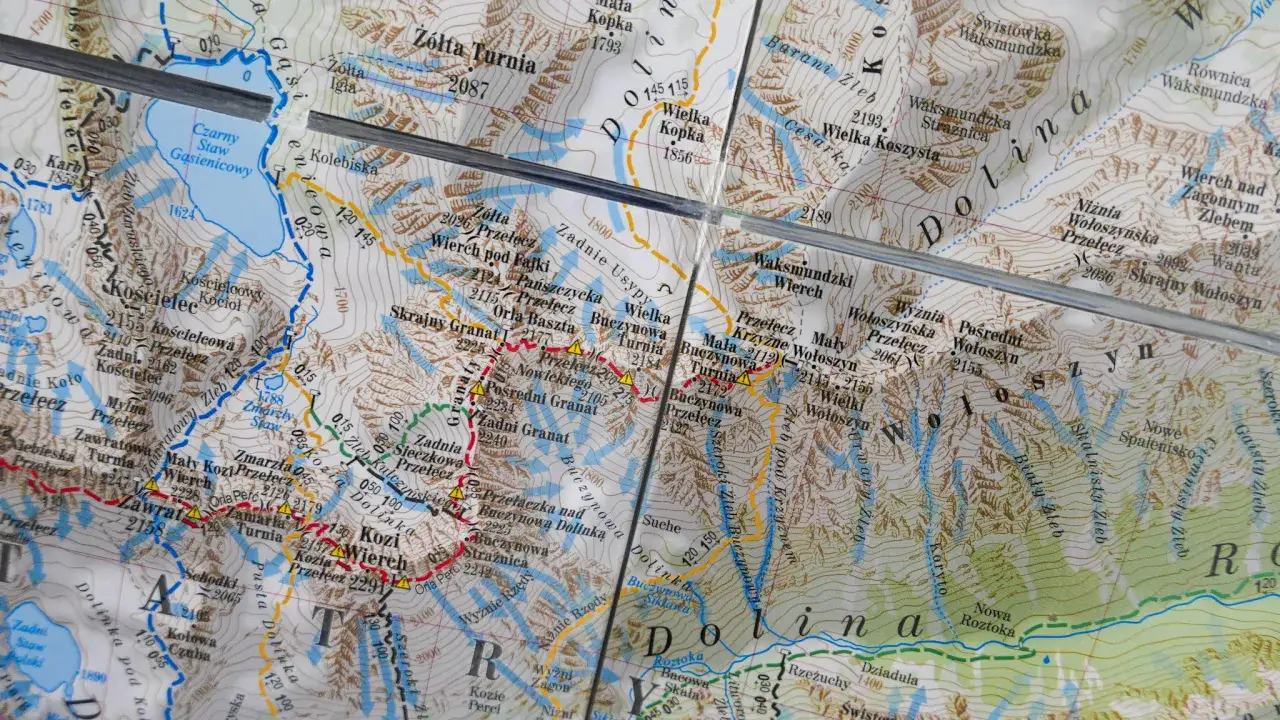 Mapa Tatr z zaznaczonymi szlakami. Szlak czarny prowadzi przez Dolinę Gąsienicową. O ile kilometrów szlak czarny jest dłuższy od niebieskiego?