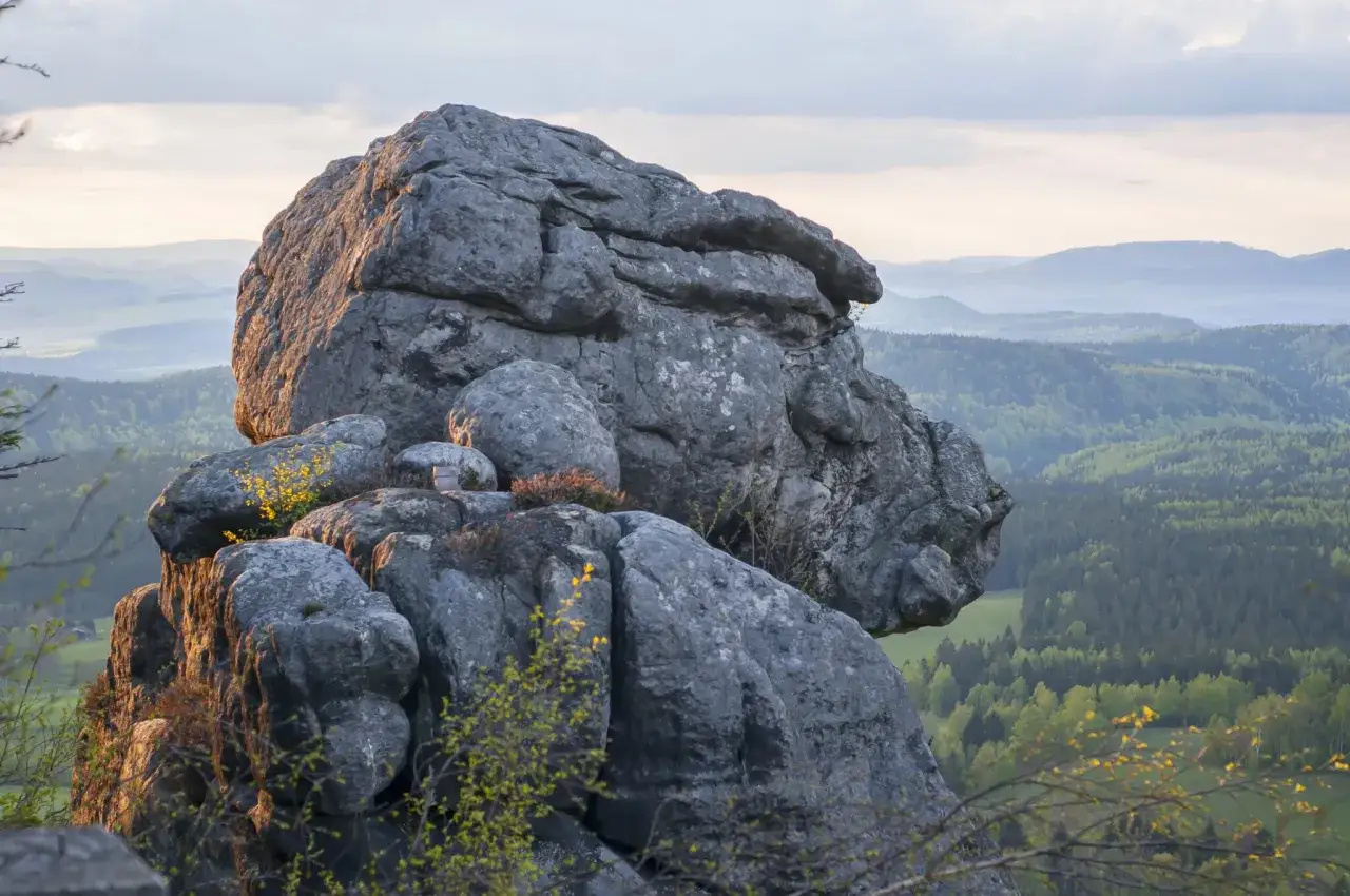 G&oacute;ry Stołowe: zobacz skalne miasto i malownicze krajobrazy. Monumentalne formacje skalne na tle zielonych wzg&oacute;rz i niebieskich pasm g&oacute;rskich.