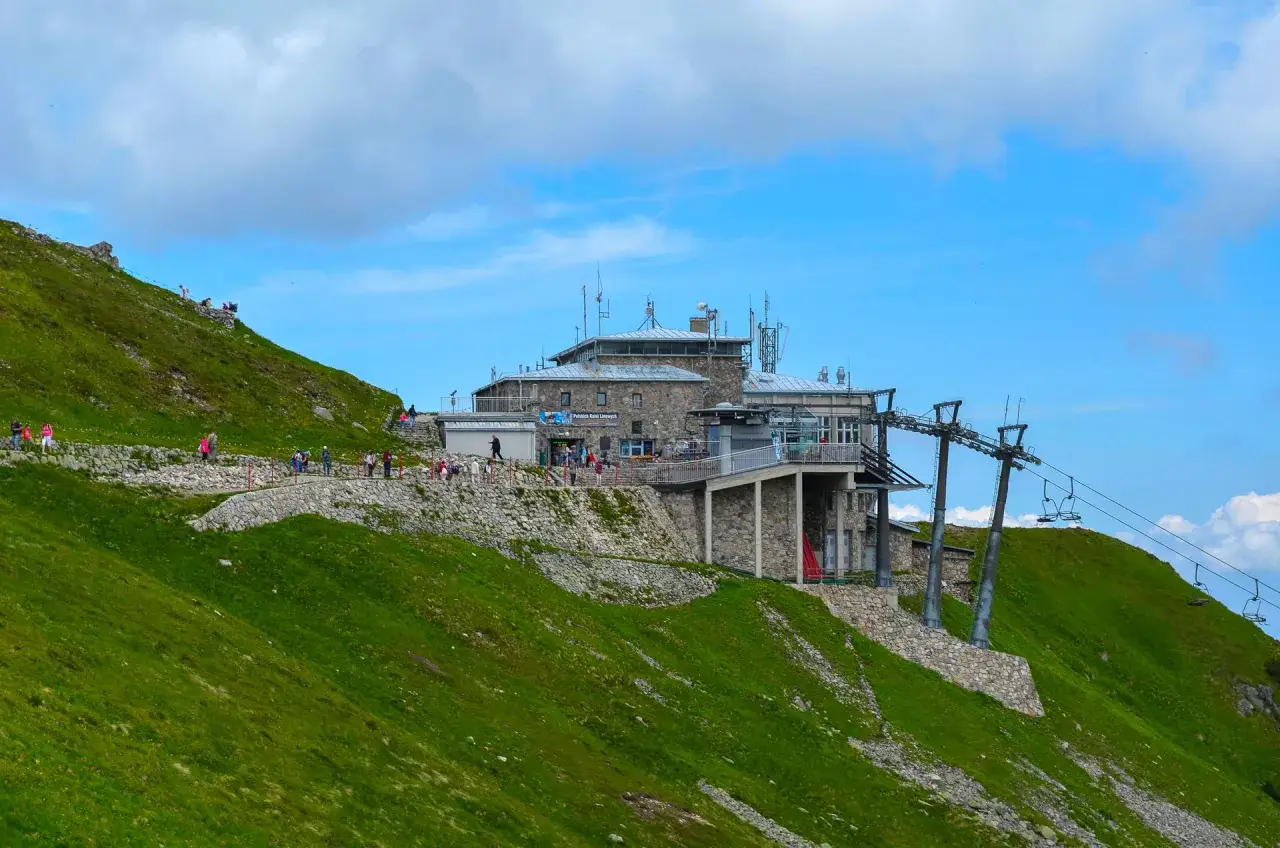 Ludzie czekają na kolejka linowa na Kasprowy Wierch. Górska panorama z budynkiem i wyciągiem.