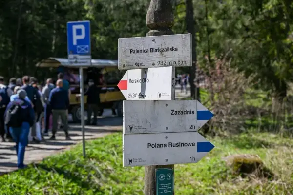 Drewniany słup z drogowskazami szlaków turystycznych w Tatrach: Palenica Białczańska, Morskie Oko, Zazadnia, Polana Rusinowa.
